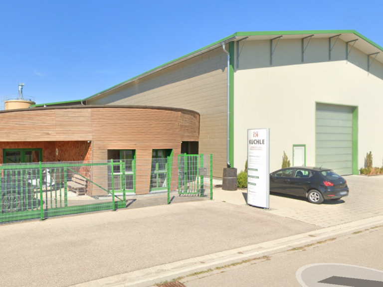 Moderne Lagerhalle mit angrenzendem Bürogebäude und Parkplatz.