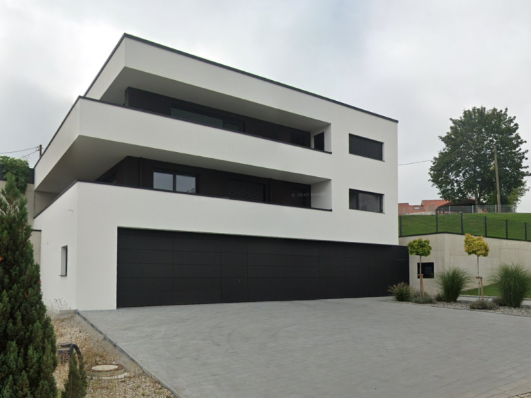 Modernes, zweigeschossiges Wohnhaus mit flachen Dächern und einer großen Garage.