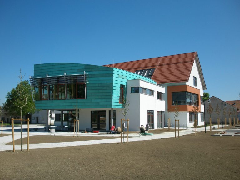 Moderne Architektur mit begrüntem Außenbereich und mehreren Erkern.